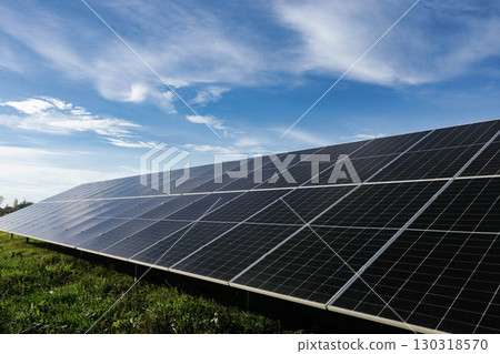 Solar panels absorbing sunlight under a cloudy blue sky Solar panels absorbing sunlight under a cloudy blue sky 130318570