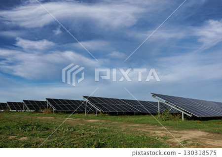 Solar panels providing clean energy under a cloudy sky 130318575