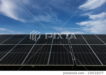 Solar panels absorbing sunlight under a cloudy blue sky Solar panels absorbing sunlight under a cloudy blue sky 130318577
