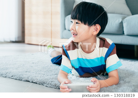 Boy playing with a smartphone Boy playing with a smartphone 130318819