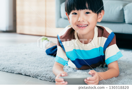 Boy playing with a smartphone Boy playing with a smartphone 130318820