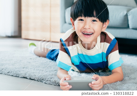 Boy playing with a smartphone 130318822
