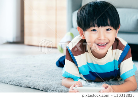 Boy playing with a smartphone 130318823