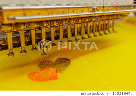 Automated embroidery machine creating colorful heart pattern on fabric, symbolizing love, creativity, and textile design process. Automated embroidery machine creating colorful heart pattern on fabric, symbolizing love, creativity, and textile design process. 130319443
