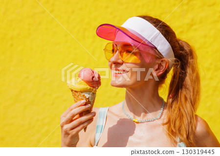Cheerful woman with ice cream cone enjoying sunny summer heat, bright colors, and vacation vibes outdoors Cheerful woman with ice cream cone enjoying sunny summer heat, bright colors, and vacation vibes outdoors 130319445