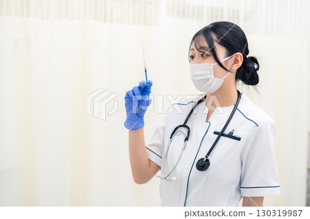 Young female healthcare worker holding a syringe Young female healthcare worker holding a syringe 130319987