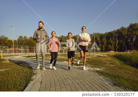 Happy Family With Children Jogging Together In The City Park At Sunset 130320177