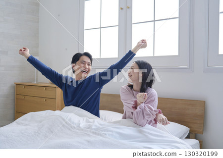 A couple in bed after waking up A couple in bed after waking up 130320199