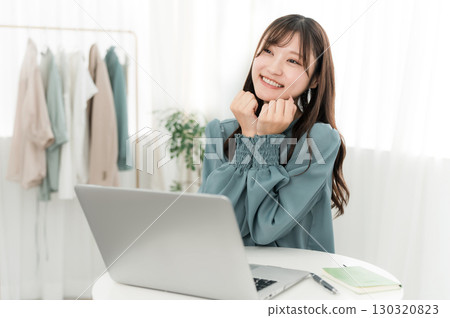 Young Asian businesswoman happy looking at computer at office/workplace 130320823