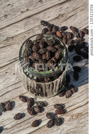 Glass jar filled with dried cornelian cherry on rustic wooden table. High quality photo Glass jar filled with dried cornelian cherry on rustic wooden table. High quality photo 130321056