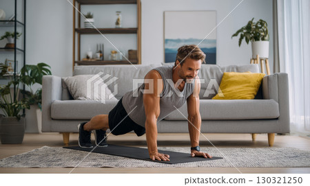 Man exercising at home doing push up on yoga mat in living room with modern decor and natural light 130321250