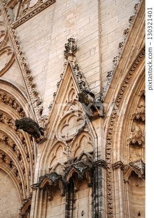 Detailed view of Gothic cathedral architecture with gargoyles and ornate stone carvings. Heritage preservation, sacred architecture, European history, cultural tourism Detailed view of Gothic cathedral architecture with gargoyles and ornate stone carvings. Heritage preservation, sacred architecture, European history, cultural tourism 130321401