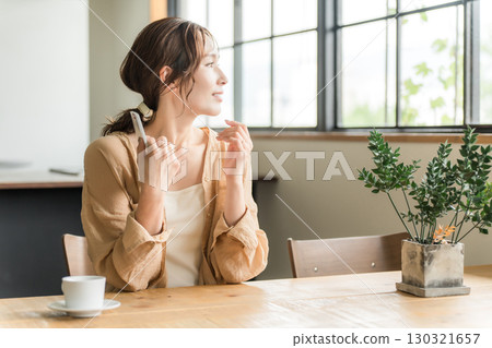 Young Asian woman drinking coffee in cafe, dining room 130321657