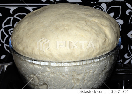 Close up of pizza bread dough that has risen over the glass bowl uncooked Close up of pizza bread dough that has risen over the glass bowl uncooked 130321805
