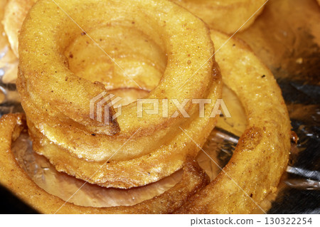 Close up of curly fries chips on foil cooked and ready to serve Close up of curly fries chips on foil cooked and ready to serve 130322254