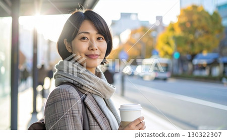 一位日本女性在公車站喝早咖啡的過肩照 130322307