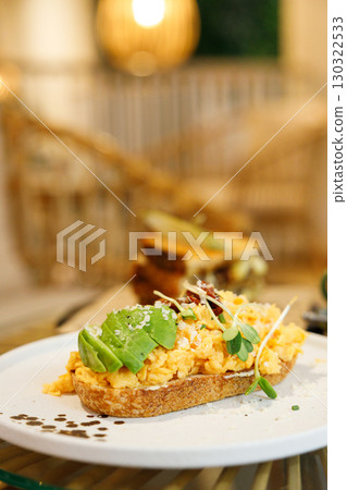 Delicious healthy breakfast plate, sourdough sandwich with scrambled eggs and avocado. 130322533