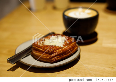 Cup of hot milk latte coffee and Mushroom danish pastry on table. 130322557