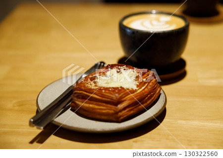 Cup of hot milk latte coffee and Mushroom danish pastry on table. Cup of hot milk latte coffee and Mushroom danish pastry on table. 130322560