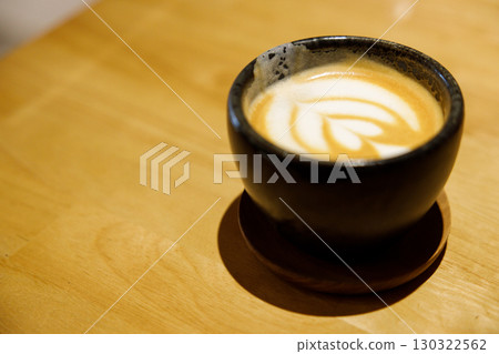 Cup of hot milk latte coffee on table. Cup of hot milk latte coffee on table. 130322562