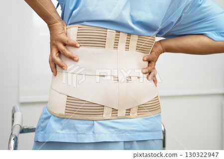 Asian woman wearing lumbar support pain back and use walker in hospital. 130322947