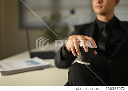 Close up of businessman in black suit holding takeaway coffee cup during work break Close up of businessman in black suit holding takeaway coffee cup during work break 130323072