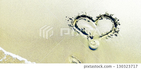 Heart shape drawn on beach sand. The waves wash away the heart drawn on the sand. Heart shape drawn on beach sand. The waves wash away the heart drawn on the sand. 130323717
