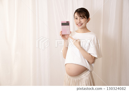 懷孕八個月的女人拿著粉紅色計算器 懷孕八個月的女人拿著粉紅色計算器 130324082