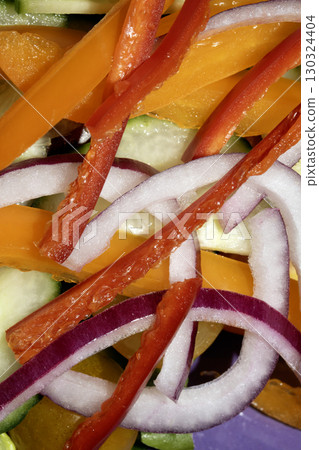 Close up of a healthy cold salad chopped tomatoes onion and cucumbers on a white background 130324404