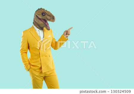 Stylish man in funny dinosaur mask, points to an empty space to copy. 130324509