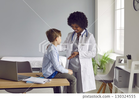 African American doctor talking to little boy patient during consultation in medical office 130324555