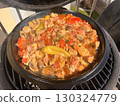 Beef meat and vegetables stew in black bowl with roasted baby potatoes. Dark background grill kamado bbq. 130324779