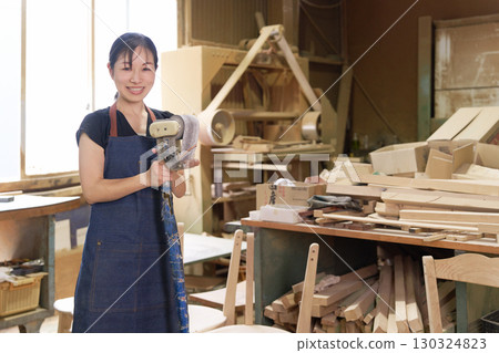 Smiling female craftsman at a furniture manufacturing factory 130324823