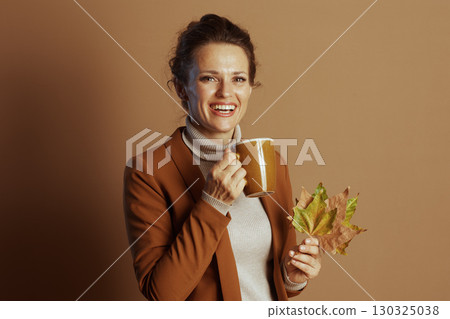 Cheerful Businesswoman with Autumn Leaves and Warm Mug Cheerful Businesswoman with Autumn Leaves and Warm Mug 130325038