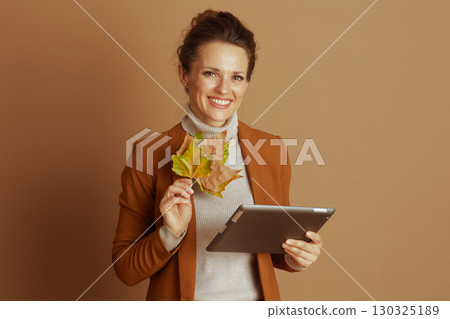 Cheerful Professional with Autumn Leaves and Tablet Cheerful Professional with Autumn Leaves and Tablet 130325189