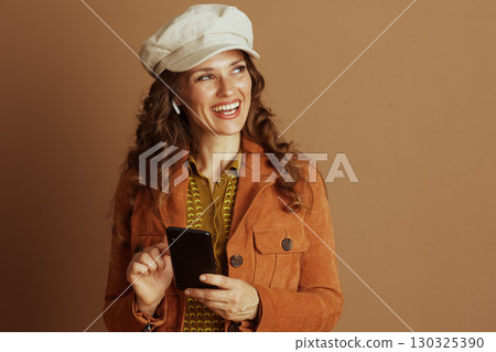 Thoughtful Woman with Smartphone in Autumn Cap Thoughtful Woman with Smartphone in Autumn Cap 130325390