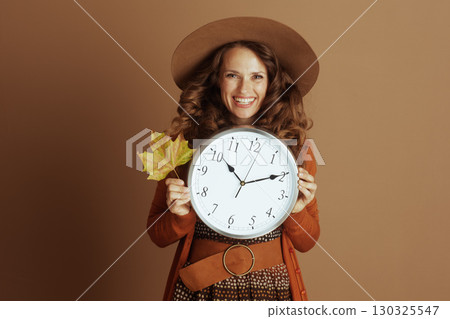 Happy Woman Embracing Autumn with Clock and Leaf Happy Woman Embracing Autumn with Clock and Leaf 130325547