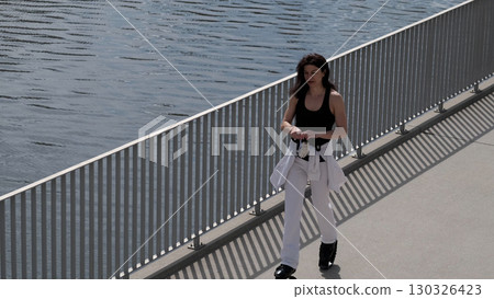 A fit woman enjoys an outdoor cardio workout, using rebound shoes for enhanced movement. Creative exercise solutions continue to redefine traditional fitness, making it more appealing and diverse. 130326423
