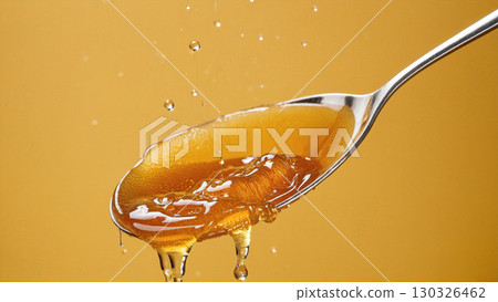 Amber honey dripping from a spoon | Delicious and natural 130326462