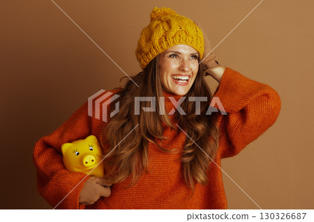 Playful Woman Saving Money with Piggy Bank Playful Woman Saving Money with Piggy Bank 130326687