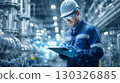 Industrial engineer taking notes while inspecting electrical panel in factory 130326885