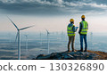 Engineers observing wind turbine operation at dusk in a wind farm 130326890