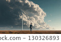 Businessman watching modern wind turbine under dramatic cloudscape 130326893
