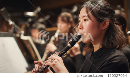 A woman plays the lead melody on the clarinet 130327034