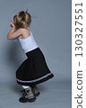A little girl expresses her playful side with a fun, energetic pose in a studio setting. The image captures the vibrant energy of childhood, paired with a stylish and modern look. 130327551