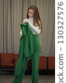 A stylish woman carrying her jacket over her shoulder, exuding elegance and confidence. The neutral background emphasizes her professional demeanor. 130327576