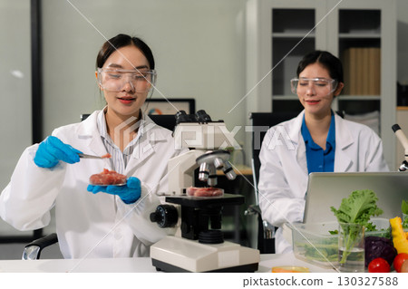 Team microbiologists and nutrition experts analyze molecular samples in advanced food science labs. 130327588