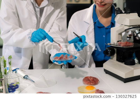 Team microbiologists and nutrition experts analyze molecular samples in advanced food science labs. 130327625