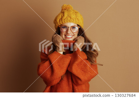 Cheerful Woman in Cozy Orange Turtleneck 130327684