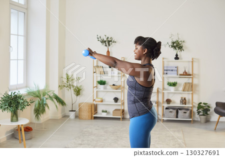 African American Woman Exercising with Dumbbells at Home African American Woman Exercising with Dumbbells at Home 130327691